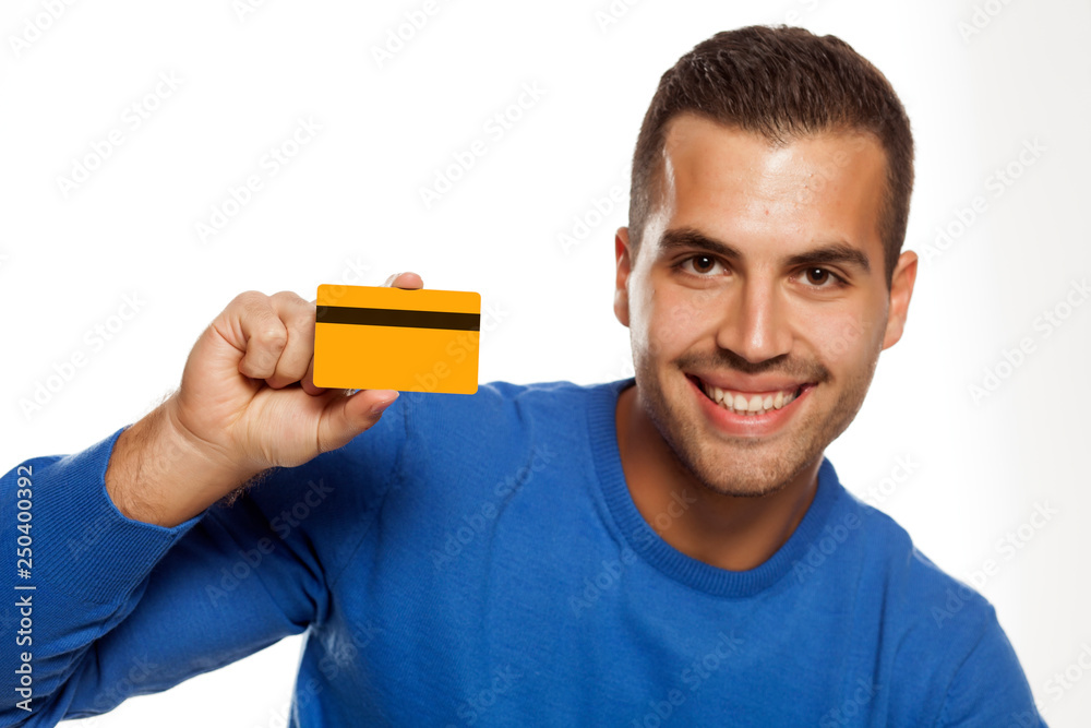 portrait of happy young man, holding empty credit card on white background portrait of happy young man, holding empty credit card on white background