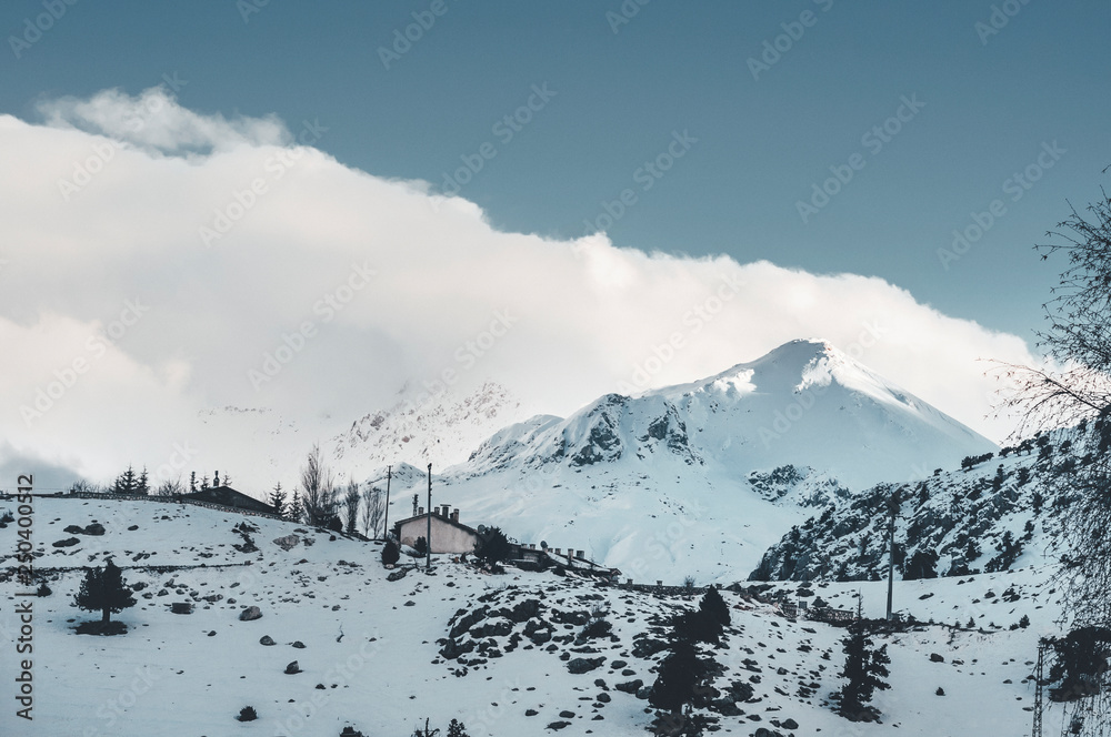 Winter landscape of snowcapped mountain with clouds. Picturesque and gorgeous snow scene.