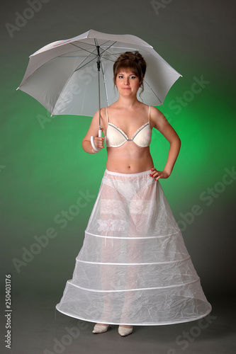 Obraz na plátně girl in a petticoat with an umbrella on a green background