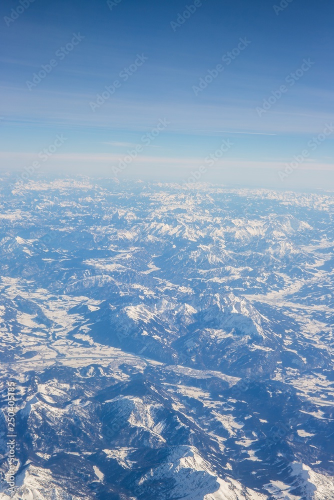 Fototapeta premium Aerial view of snow covered mountains - snowy mountain peaks - high mountains - Alps
