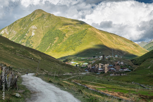Old authentic Ushguli village with famous svan towers far in the distance in georgian mountains