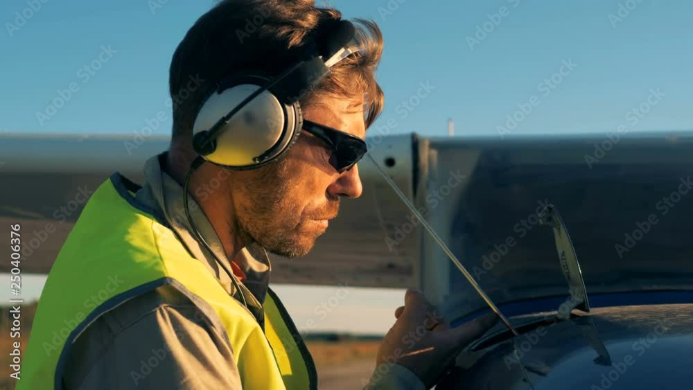 Pilot checking level of motor oil on an airplane, close up. Pilot checking level of motor oil on an airplane, close up.