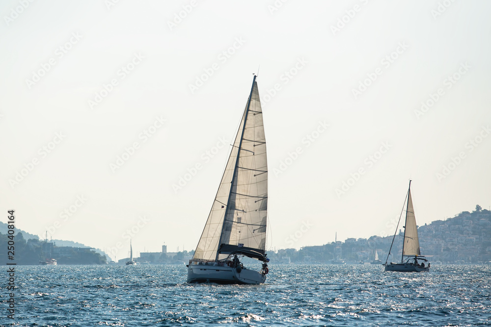 Yachts at Sailing regatta in the wind through the waves at the Sea.