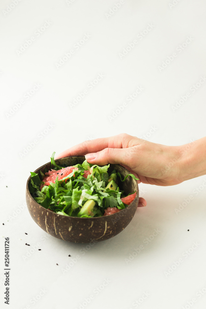 healthy green vegan salad in coconut bowl
