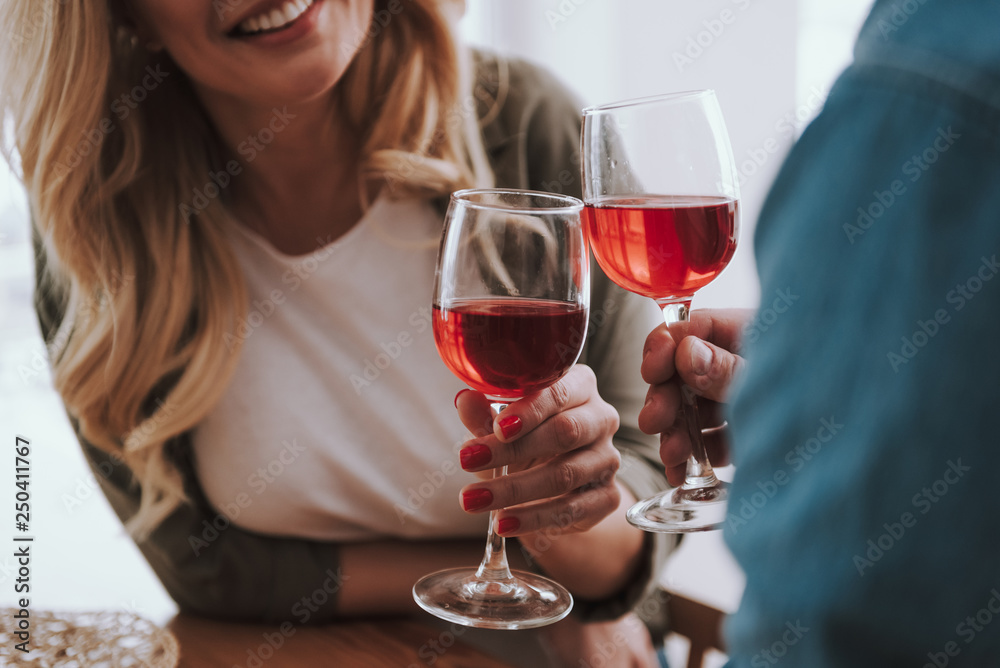 Loving couple toasting with glasses of red wine at home Loving couple toasting with glasses of red wine at home