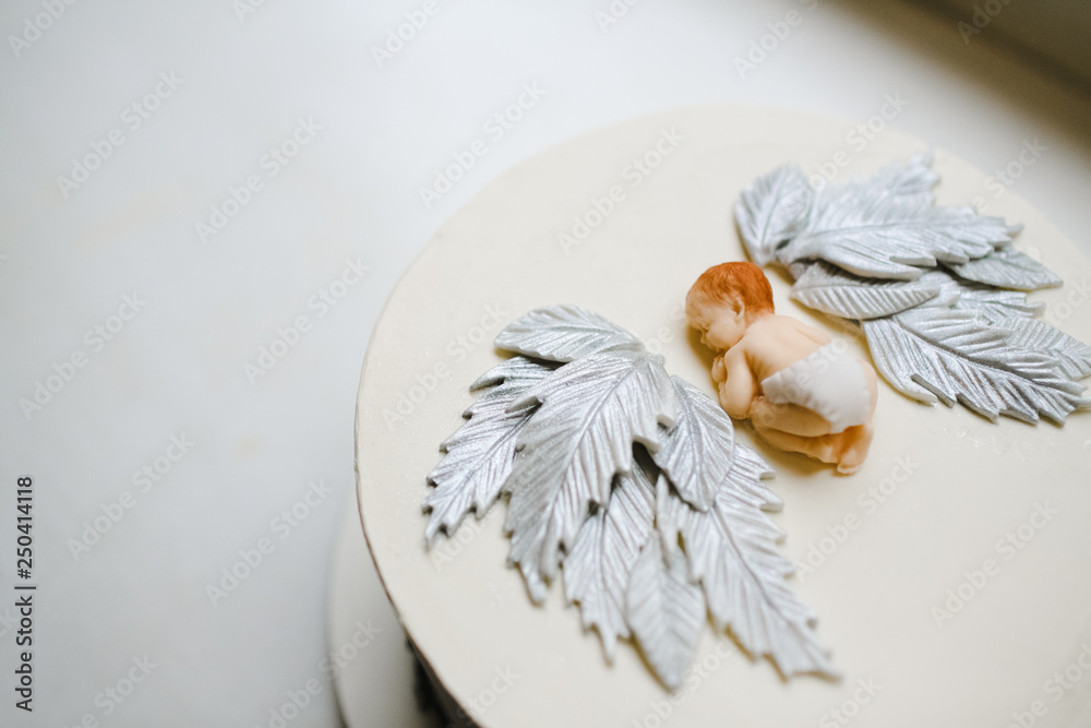 Figure of little baby with wings made on a white cake for baby's birthday