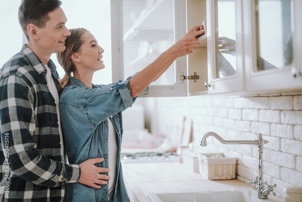 Obraz premium Woman putting cup on the shelf and man hugging her