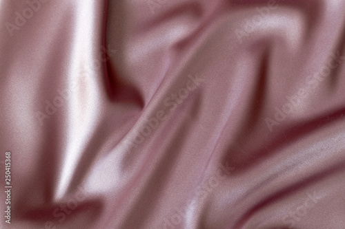 Texture and draping of beautiful satin pink fabric. Textile background
