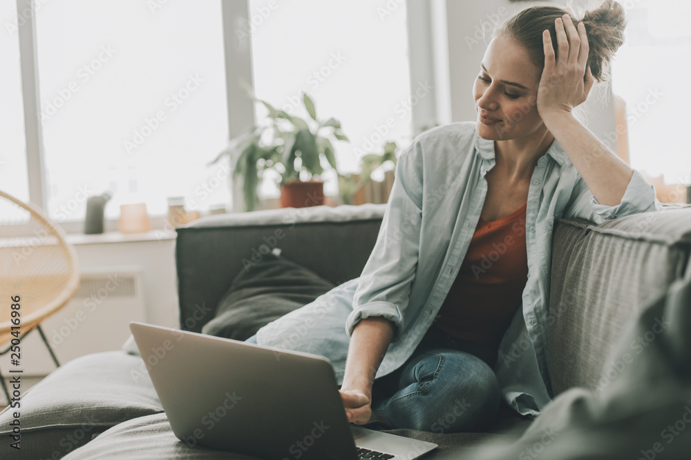 Relaxed female sitting on couch with laptop Relaxed female sitting on couch with laptop