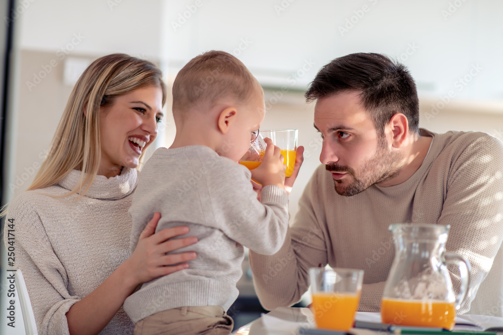 Family with child having fresh fruit juice at home Family with child having fresh fruit juice at home