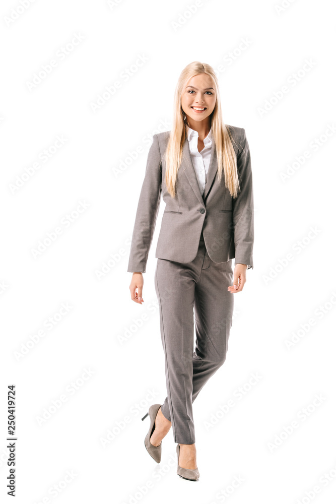 smiling blonde businesswoman posing in grey suit isolated on white
