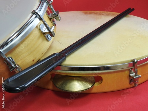 Close-up of two Brazilian percussion musical instruments: pandeiro (tambourine) and tamborim with drumstick. The instruments are widely used to accompany samba, a popular Brazilian rhythm.  photo