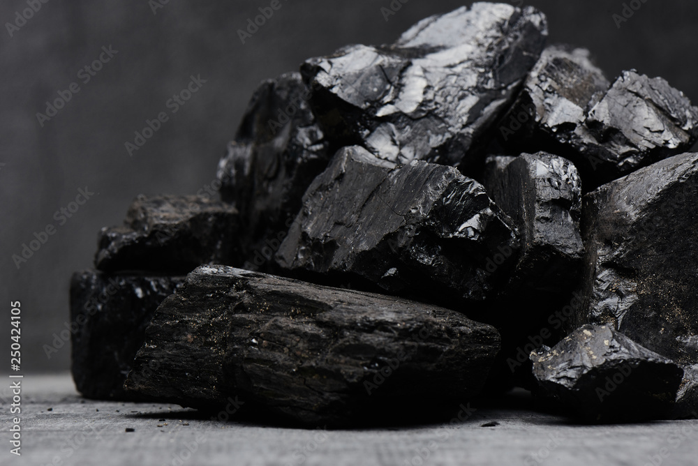 Natural coal on a black background isolated closeup. Extraction of natural mineral resources.