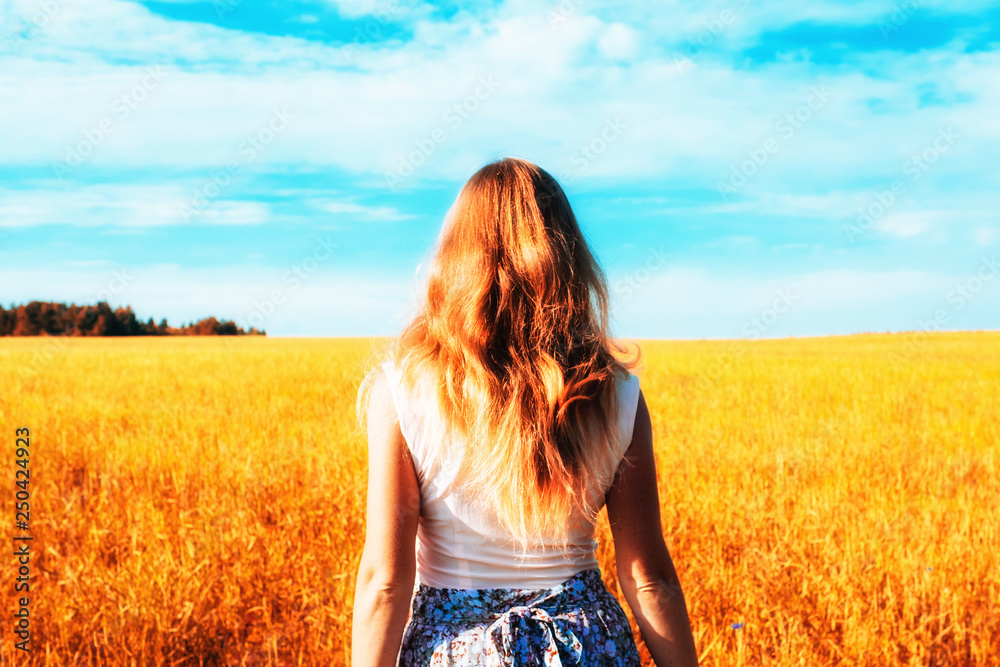 Young woman in dress walking along cereal field Young woman in dress walking along cereal field