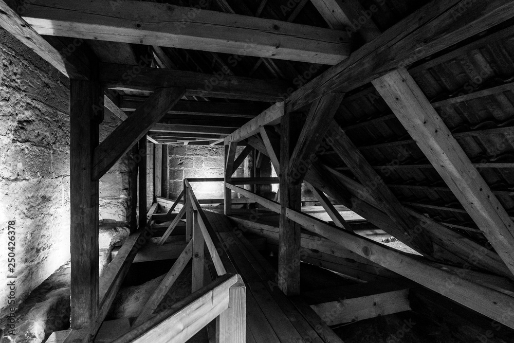 Wooden structures (rafters and beams) of the attic of an old house. Black and white.