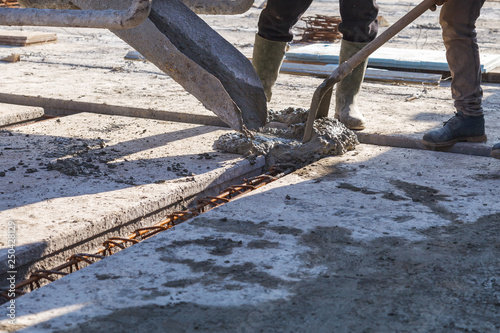 Worker pouring concrete mix at home foundation