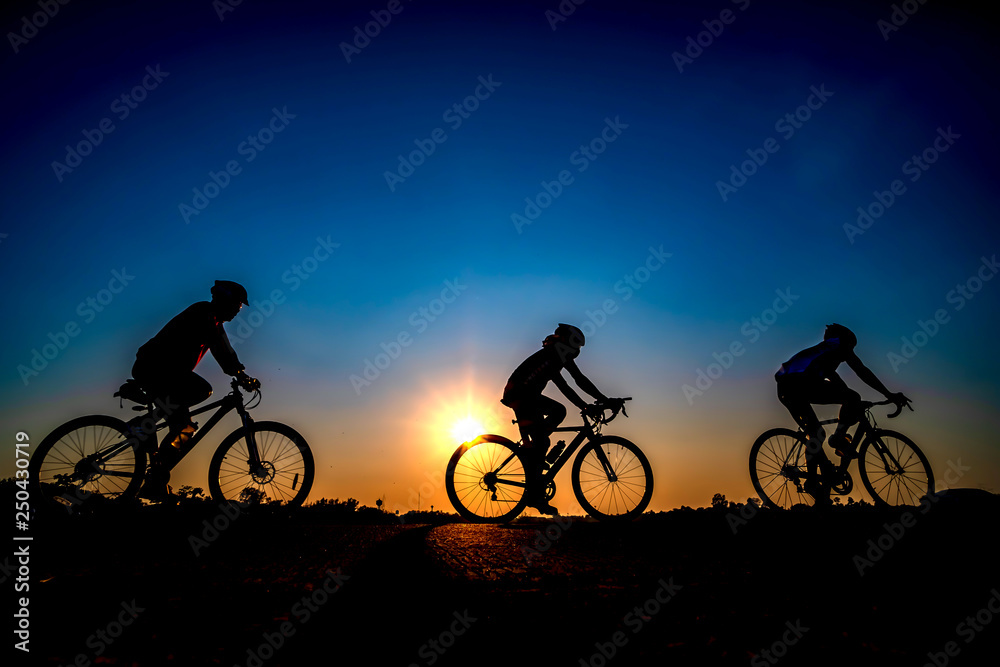 Silhouette of cyclist in sunset background.