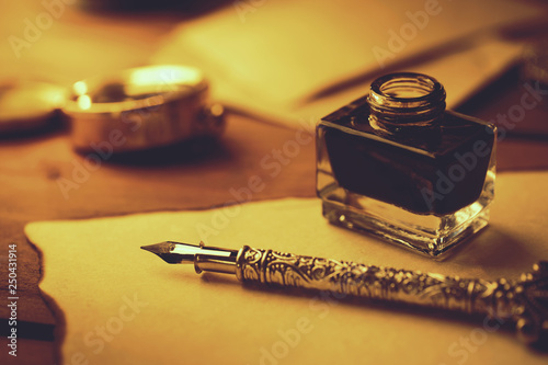 vintage literature - retro feather pen and inkwell on old parchment paper