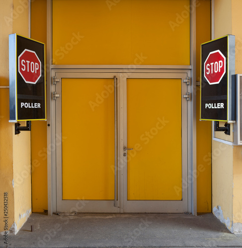 Stop signboards next to the yellow door