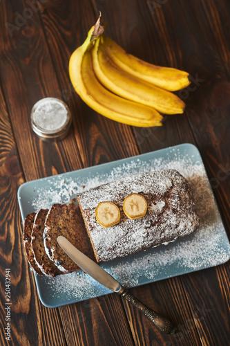 homemade sliced banana cake decorated with sugar powder and three banana