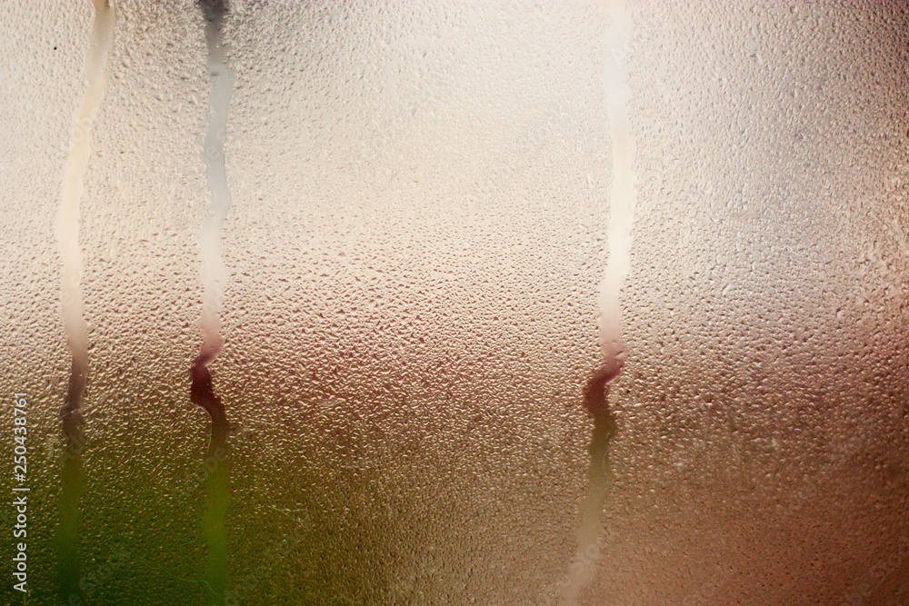 Fototapeta premium Texture of the rain on the window glass. Illuminated background.