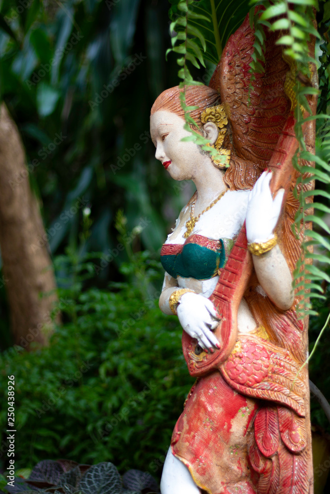 A fairy statue surrounded by a complete forest A fairy statue surrounded by a complete forest