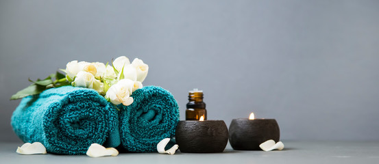 Foto auf Acrylglas Massagesalon Spa still life with candles, towels and flowers on grey background copy space  © marrakeshh