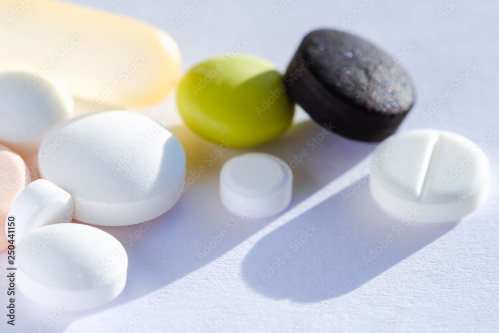 Pill tablet multicolor medicine lying isolated on white, extreme close-up macro. Pill tablet multicolor medicine lying isolated on white, extreme close-up macro.