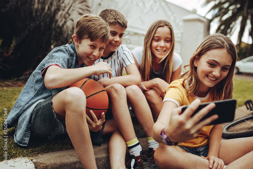 Obraz premium Kids taking a selfie sitting outdoors