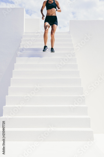 Female athlete running down the stairs of a building