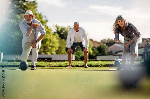 Elderly couple playing boules in a park