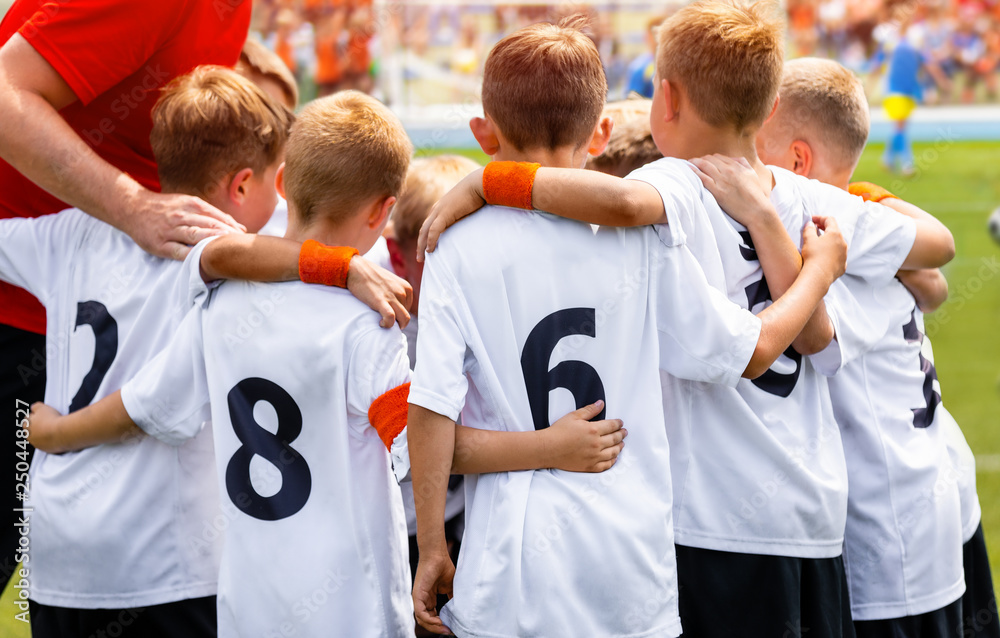 Young Boys In Football Team. Group Of Children In Soccer Team. School Football Coach’s Pregame Speech. Coaching Youth Sports Young Boys In Football Team. Group Of Children In Soccer Team. School Football Coach’s Pregame Speech. Coaching Youth Sports