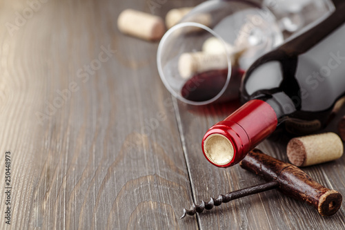 Glass bottle of wine with corks on wooden table background.Top view with copy space