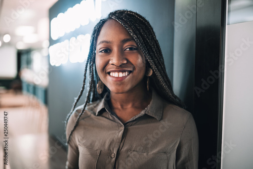 Slika na platnu Portrait of a smiling beautiful young black african student with long braided ha