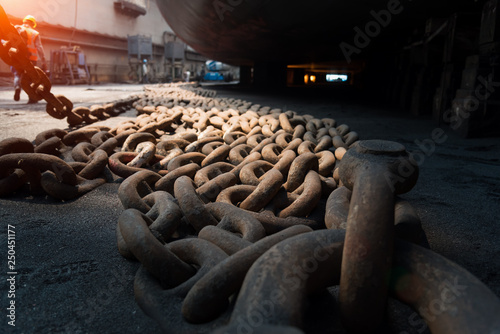Φωτογραφία Close up view of big metal anchor chain of cargo ship in dry dock for repairs an