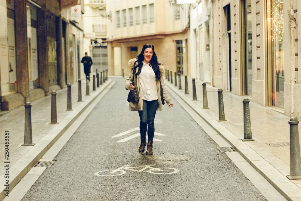 Happy woman walking through the streets of a city. Happy woman walking through the streets of a city.