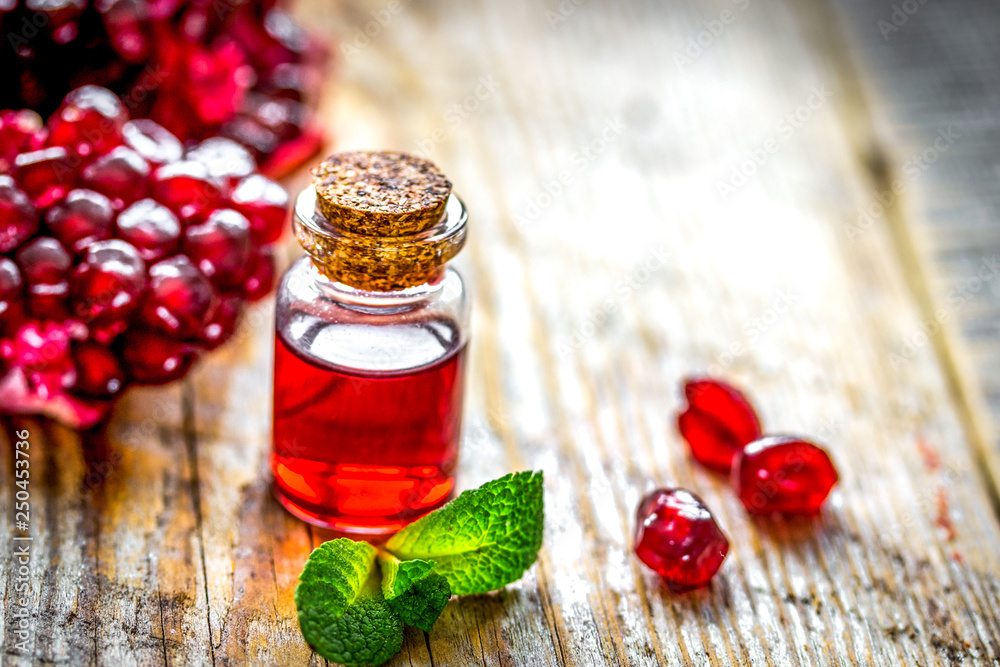 sliced pomegranate and extract in glass on wooden background sliced pomegranate and extract in glass on wooden background