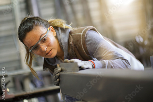 Foto Woman apprentice training in metalwork workshop