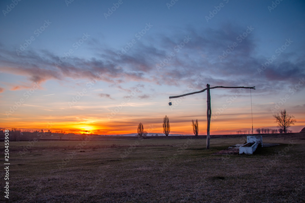 Traditional water well (well sweep or shadoof) in Serbia with a beautifull sunset