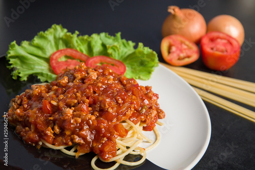 Spaghetti with pork in black and white dish