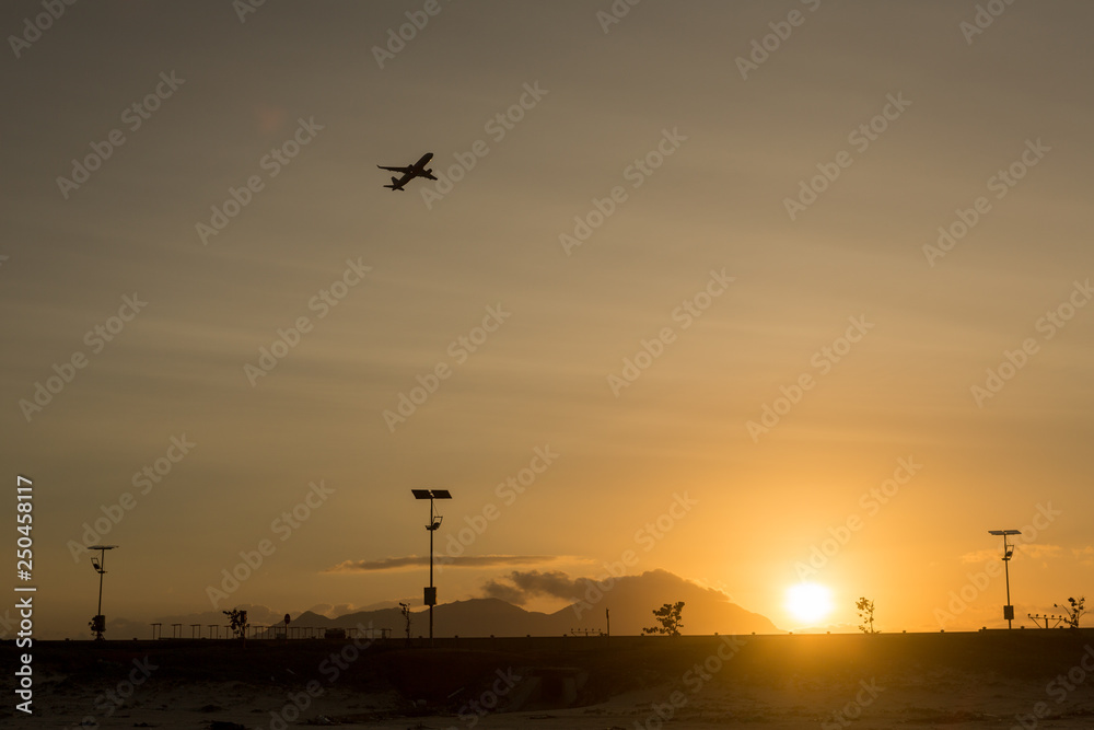 Silhouette takeoff plane from the airport while sunset