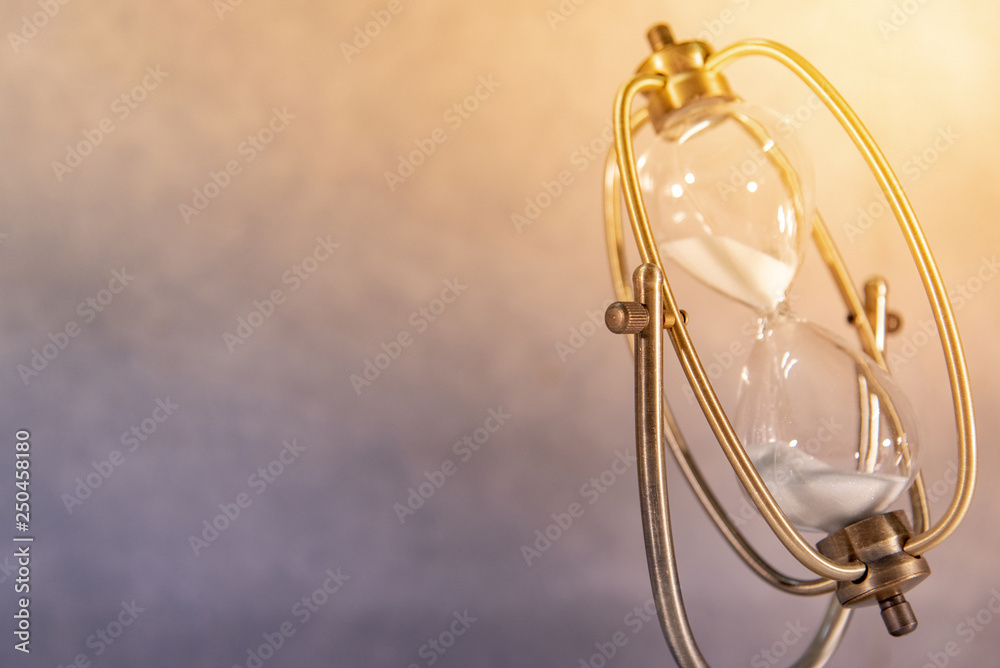White sand running through the shape of vintage hourglass.Time passing and running out of time. Urgency countdown timer for business deadline concept