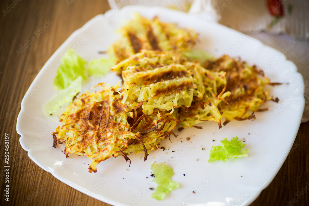 grilled potato pancakes in a plate, on a wooden table grilled potato pancakes in a plate, on a wooden table