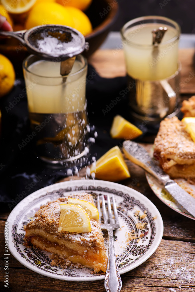 Pieces of lemon pie on a plate and tea in glasses