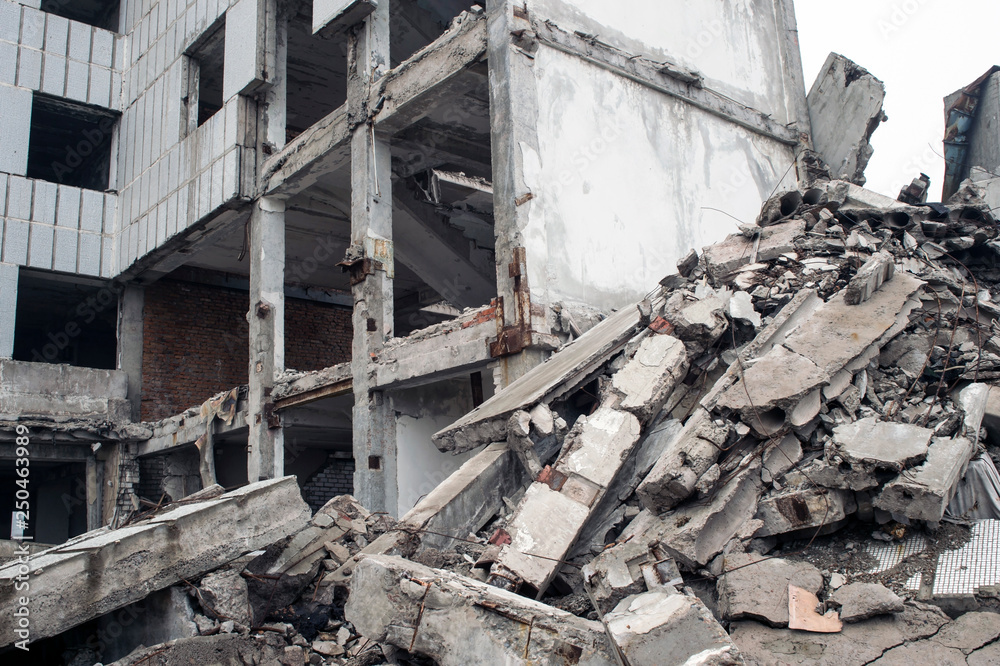 A huge pile of gray concrete debris from piles and stones of the destroyed building. The impact of the destruction.