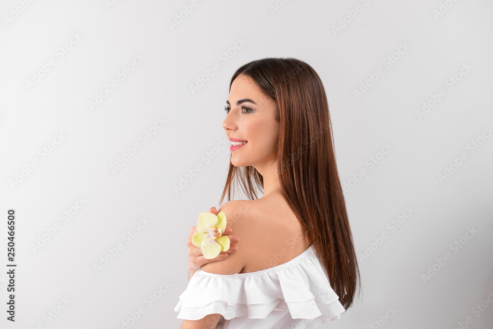Beautiful young woman with orchid flower on white background Beautiful young woman with orchid flower on white background