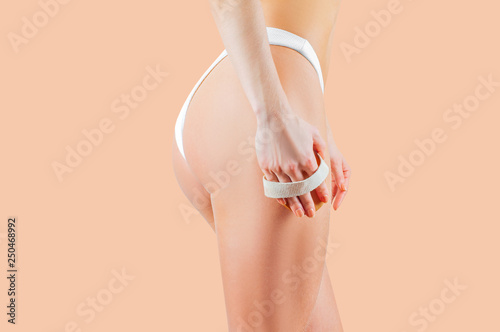 Woman make anti cellulite massage on pastel background
