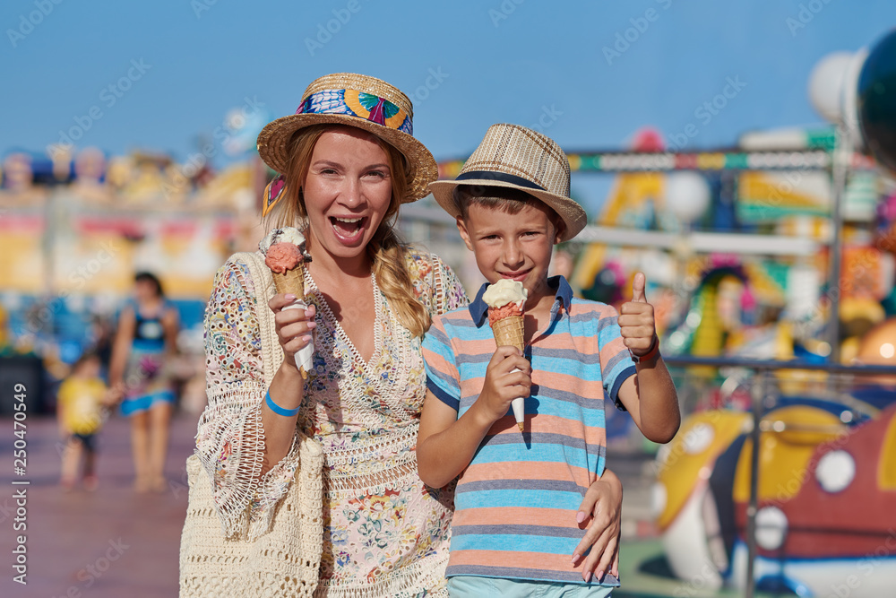 Beautiful European woman and her son eating ice-cream in the Luna Park.