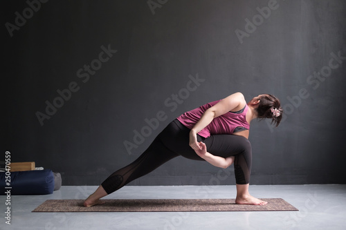 woman doing Extended Side Angle posture, Utthita Parsva Konasana from back side