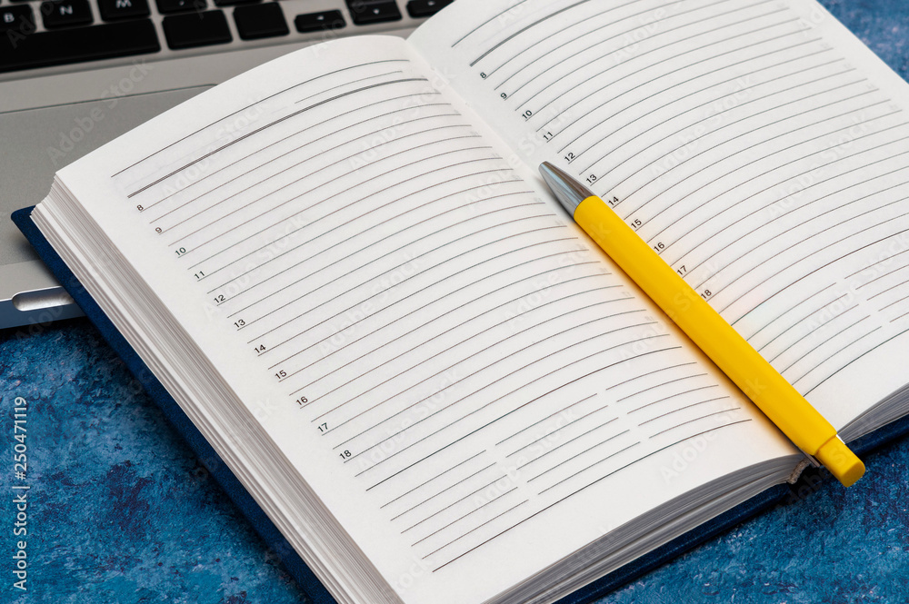 Opened clean business notebook and laptop. Business notebook for record important events and meetings with business partners on the marble table Opened clean business notebook and laptop. Business notebook for record important events and meetings with business partners on the marble table